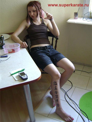 Татуировка на голени у спортсменки-каратистки.